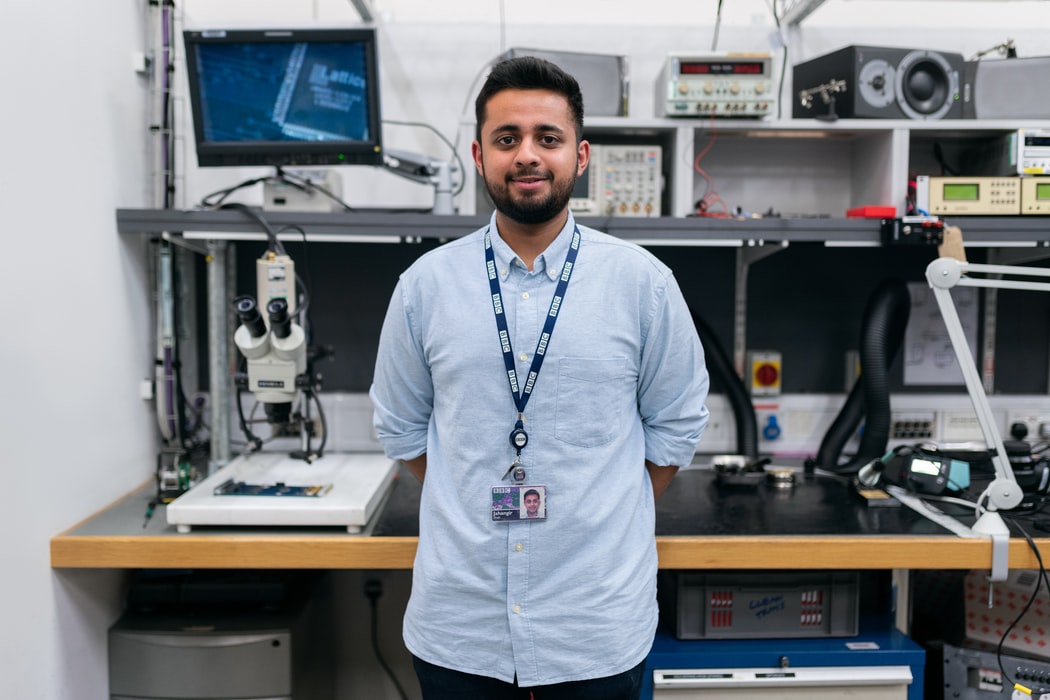 man standing in front of a desk full of tech equipment