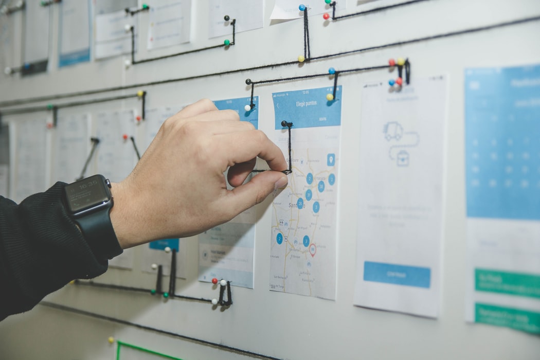 person planning out on a board with blue and white paper